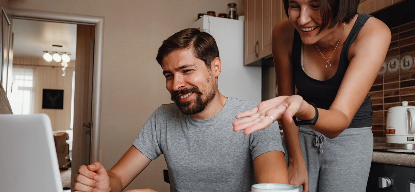Couple in kitchen on their computer